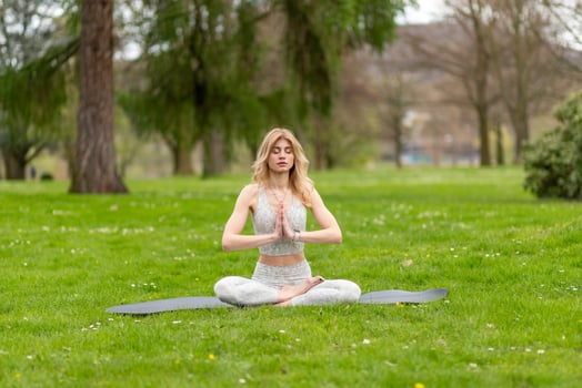 Woman in lotus pose meditating in park photo
