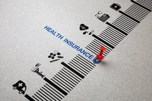 Red pin down word Health Insurance with medical icon on paper. Concept of health insurance planning, financial risk protection for medical expenses, and assisting in managing health risks. photo