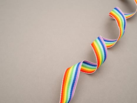 Rainbow cloth ribbon on a gray background. Top view. photo