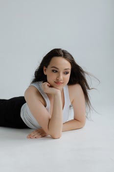 Girl lying on the floor smiling and wearing casual clothes photo