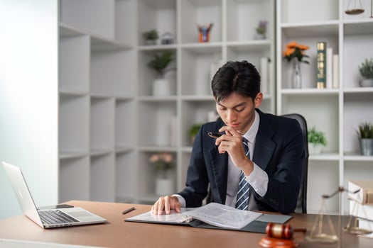 Young businessman reviewing important documents and contemplating strategy in a modern office. photo