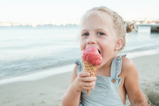 Happy girl enjoying ice cream on beach photo