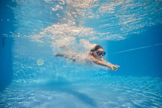 Active boy swimming underwater of clear pool photo