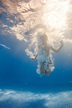 Small boy swimming in bubbling water in pool photo