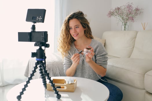 Female beauty blogger shooting on camera at home photo