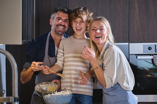 Happy family with faces dirty of dough cooking together at home photo