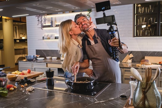 Wife kissing husband while taking selfie photo