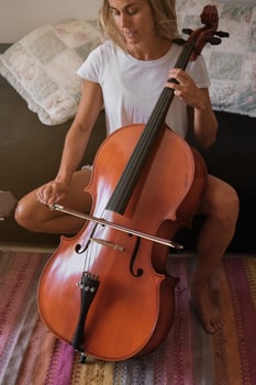 Crop woman playing cello at home photo