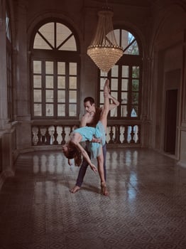 Ballerina doing standing split with help of partner in palace photo