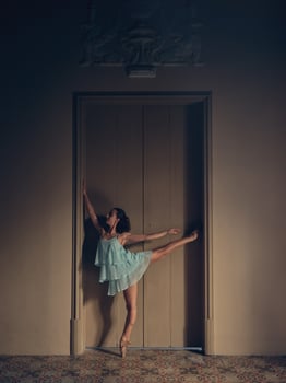 Ballerina standing near room door photo