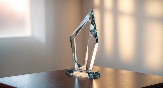 A glass award on a table in front of a window photo