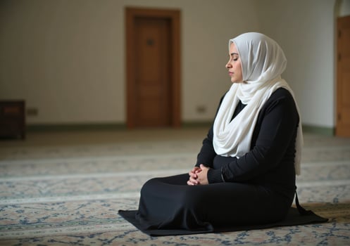 A woman in a hijab sitting on the floor in a mosque photo