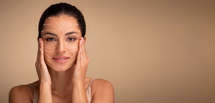 Middle Eastern woman is gently massaging her face, focusing on skincare and anti-aging techniques. The relaxed atmosphere highlights her commitment to self-care and beauty rituals, copy space photo