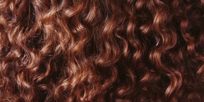Beautifully textured curly hair showcasing rich brown tones in natural light photo