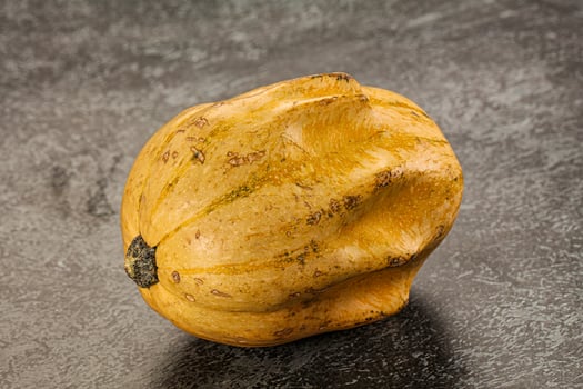 A yellow squash on a table photo