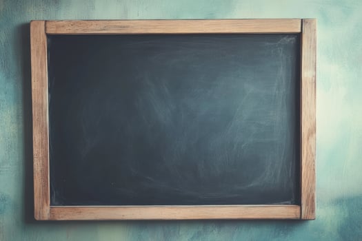 Blank chalkboard on a textured wall ready for lessons and creative ideas photo