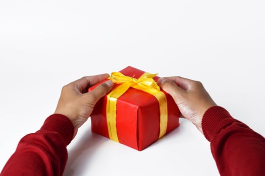 Holding a Red Gift Box with a Hand in a Cozy Red Sweater photo