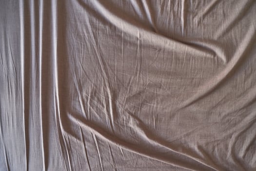 Natural beige fabric with wrinkles and texture highlighting soft cotton material surface. photo