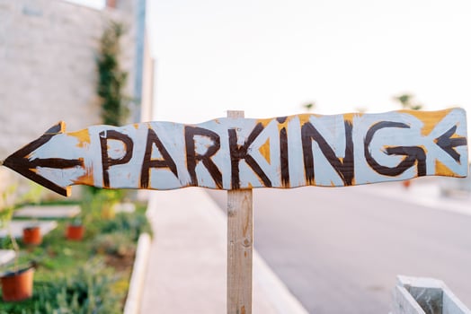 Wooden pointer with an arrow. Caption. Parking photo
