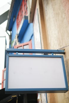 Blank sign outside a colorful building in a vibrant neighborhood photo