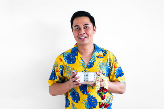 Thai male holding water bowl and garland with colorful shirt for Thailand Songkran festival concept. photo