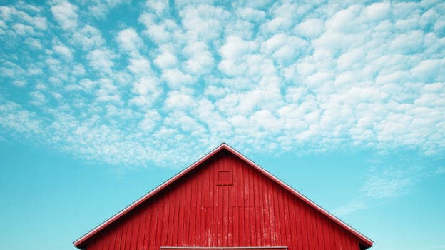 A red barn with a blue sky in the background. The barn is the main focus of the image, and the blue sky in the background creates a sense of calm and serenity photo