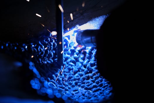 Worker welding metal around stick photo