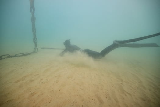 Anonymous diver with harpoon hunting in deep sea photo