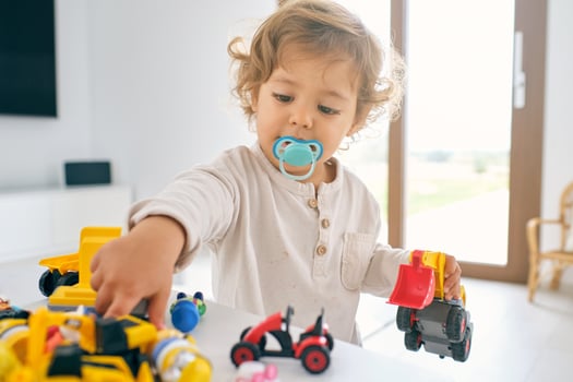 Cute kid playing with toys in light apartment photo