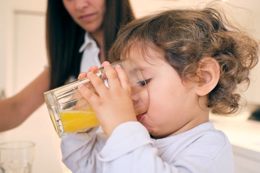 Little boy drinking orange juice photo