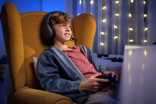 Boy in headphones playing videogame photo