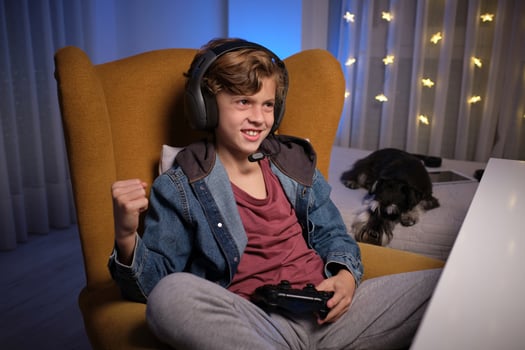 Cheerful boy in headphones playing videogame photo