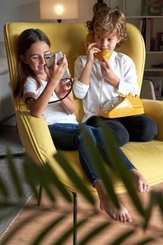 Content children using old telephone and new smartphone photo