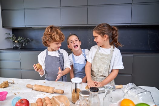Happy children making cookie dough photo