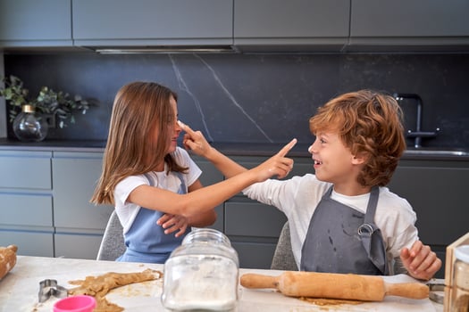 Smiling boy and girl bonding while cooking photo