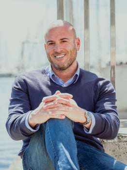 A man sitting on a bench near a body of water photo