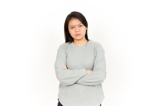 A woman in a gray sweatshirt standing with her arms crossed photo