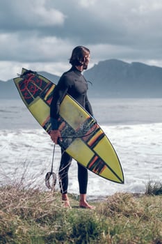 Fit male surfer admiring wavy sea after surfing photo