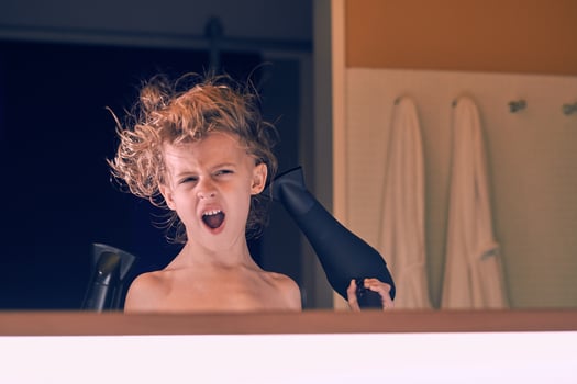 Cute boy blow drying hair photo