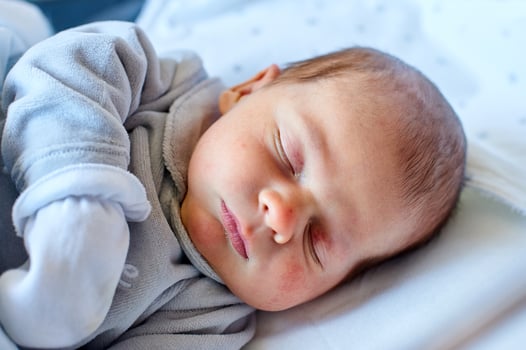 Newborn baby sleeping in its hospital crib photo
