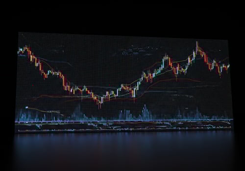 Financial market analysis shown via candlestick chart reflecting on a dark surface. photo