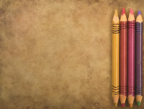 Four Colored Pencils on Tan Textured Background photo