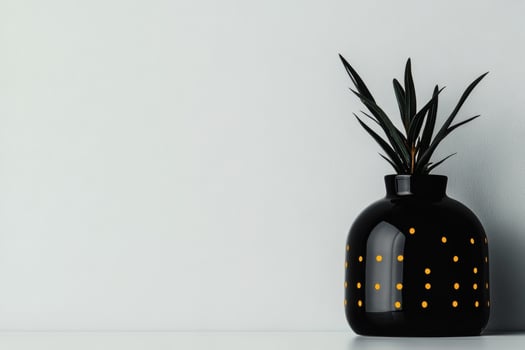 Modern black vase with yellow dots and plant photo