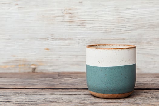 Handmade ceramic cup on rustic wooden table photo