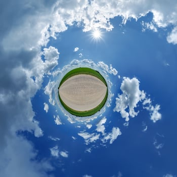 A small planet with a blue sky and clouds photo