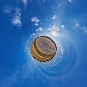 A small planet with a blue sky and clouds photo