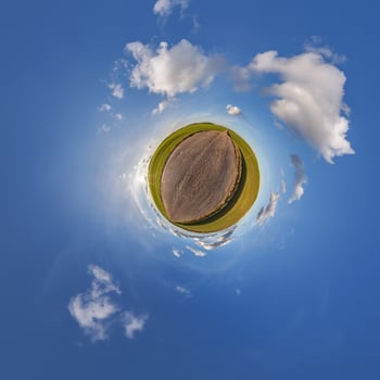A small planet with a field and clouds photo