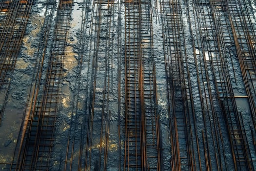 Rusty rebar emerging from wet concrete at construction site photo