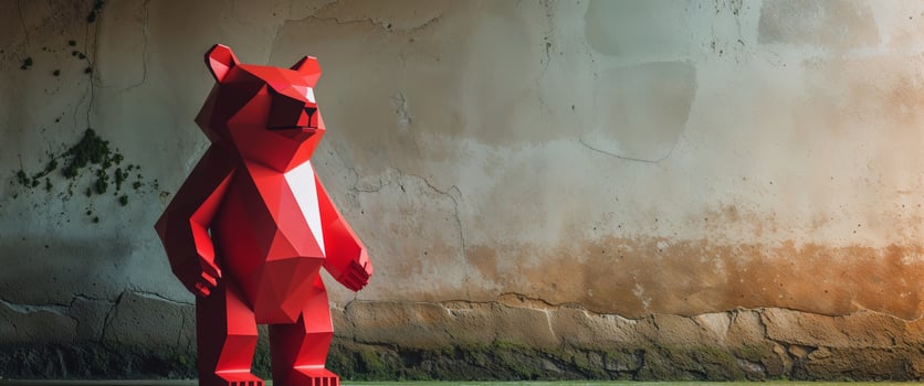 A red paper bear standing in front of a wall photo