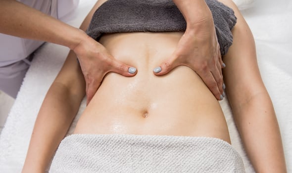 Beautiful young woman enjoying massage in spa salon. Cosmetology photo